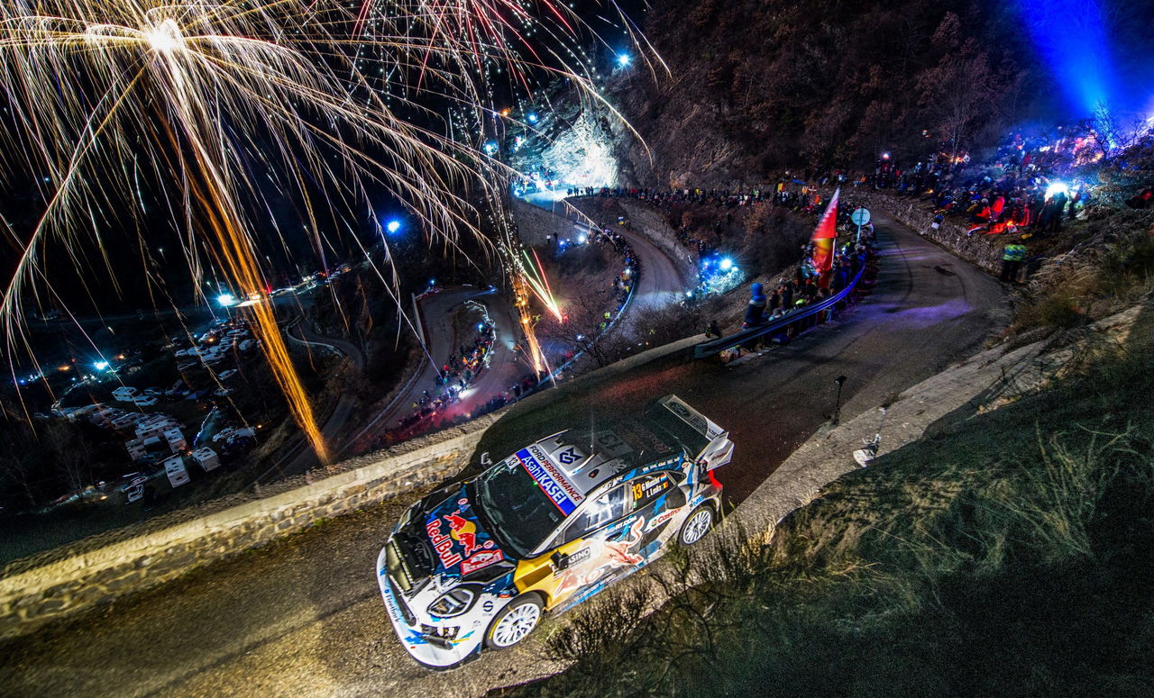 Impresionante vista del rally con fuegos artificiales y el coche en acción.