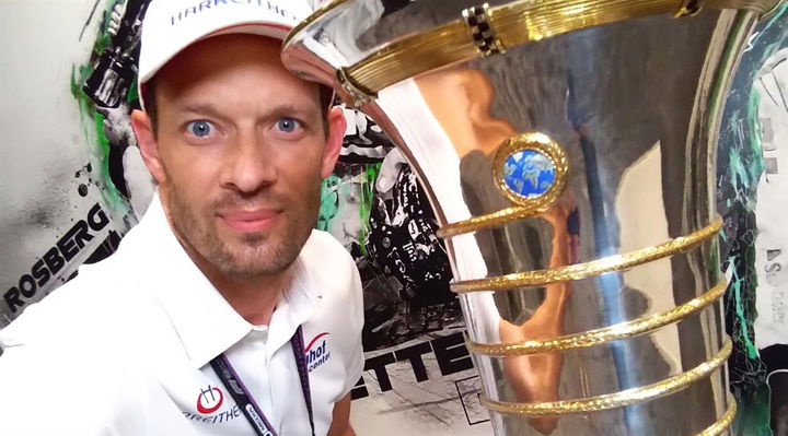 Álex Wurz posa con el trofeo de la Fórmula 1, reflejando la emoción del evento.