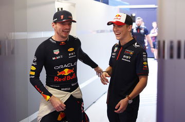 Liam Lawson y Max Verstappen conversan antes de la carrera, mostrando la camaradería del equipo.