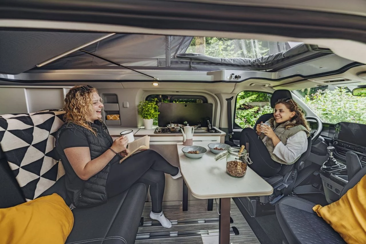 La camper presenta un interior espacioso y acogedor, ideal para viajes cómodos.