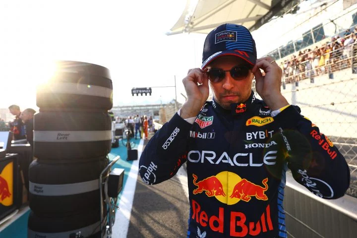 Checo Pérez ajustándose las gafas en el pit lane, listo para la carrera