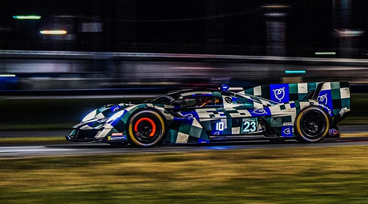 Captura dinámica del Aston Martin Racing Valkyrie en plena carrera nocturna.