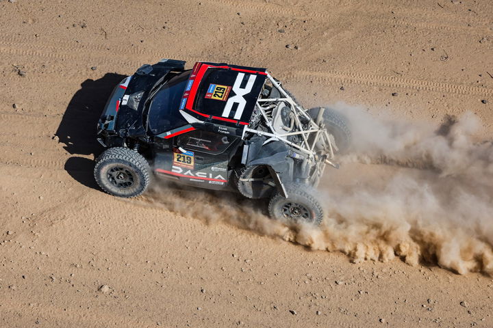 El Dacia se desliza por la arena, demostrando su agilidad en el Dakar 2025.