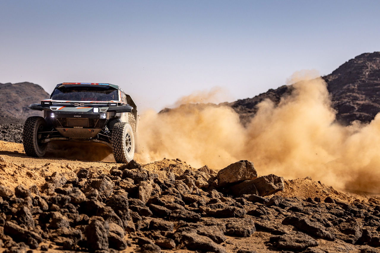 El icónico vehículo de rally surca el desierto, mostrando su potencia y diseño robusto.