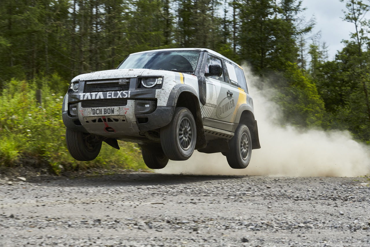 El Land Rover Defender se muestra en acción, saltando en plena competición. 