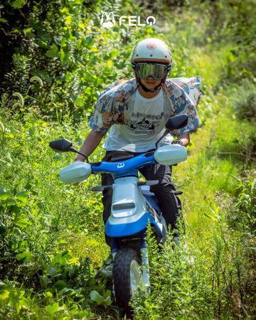 El piloto navega por la naturaleza con la Felo moto FW03, destacando su diseño y robustez.