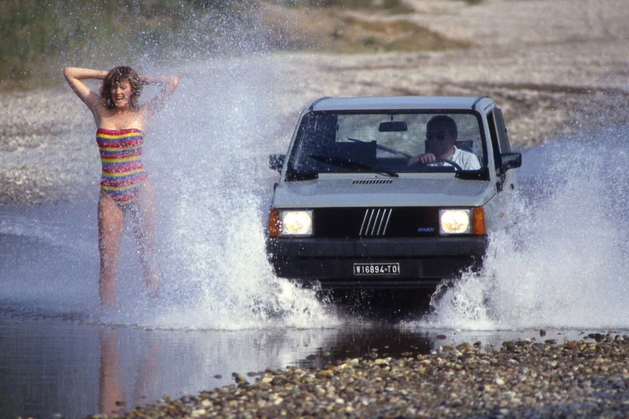 El FIAT Panda 4x4 surca el agua con destreza, mostrando su capacidad off-road.