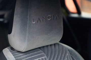 Vista del respaldo del asiento con el logo de Lancia, demostrando su diseño elegante.