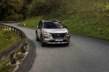 El Nissan X-Trail 2025 muestra su diseño robusto y elegante en una carretera sinuosa.