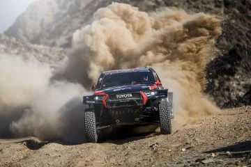 El Toyota se enfrenta a terrenos difíciles en el Dakar 2025, desafiando polvo y obstáculos.