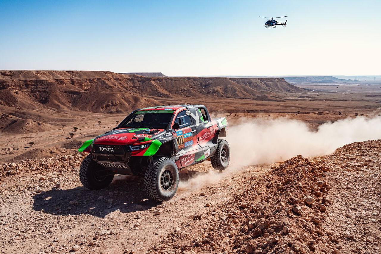 Un coche de rally compitiendo en un paisaje desértico durante Dakar 2025.