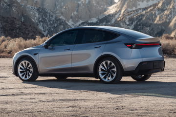 Vista lateral y trasera del Tesla Model Y 2025, destaca su aerodinámica y diseño elegante.