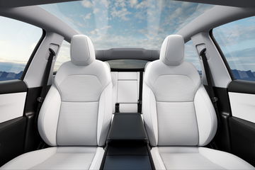 Interior del Tesla Model Y 2025 con asientos blancos y elegante diseño.