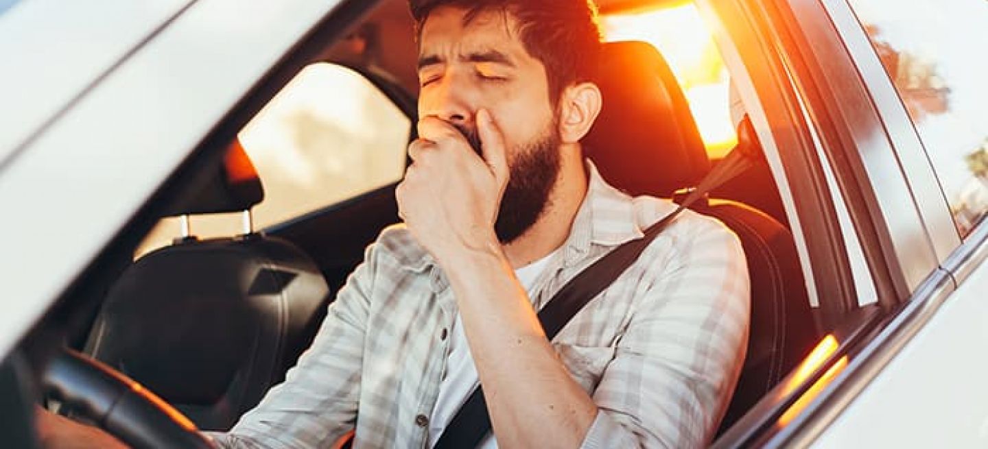 Tired Man Yawning While Driving His Car