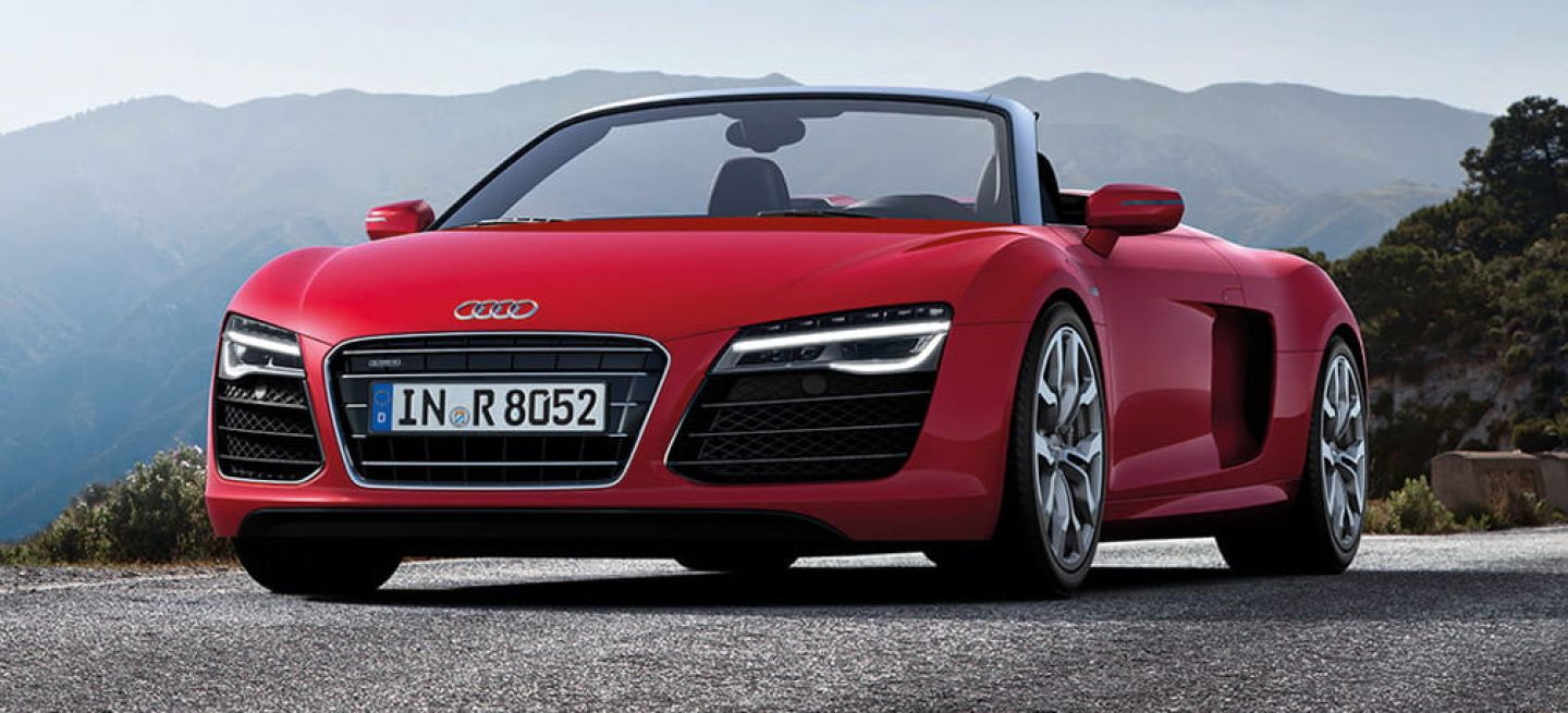 Vista frontal y lateral del Audi R8 Spyder en color rojo.