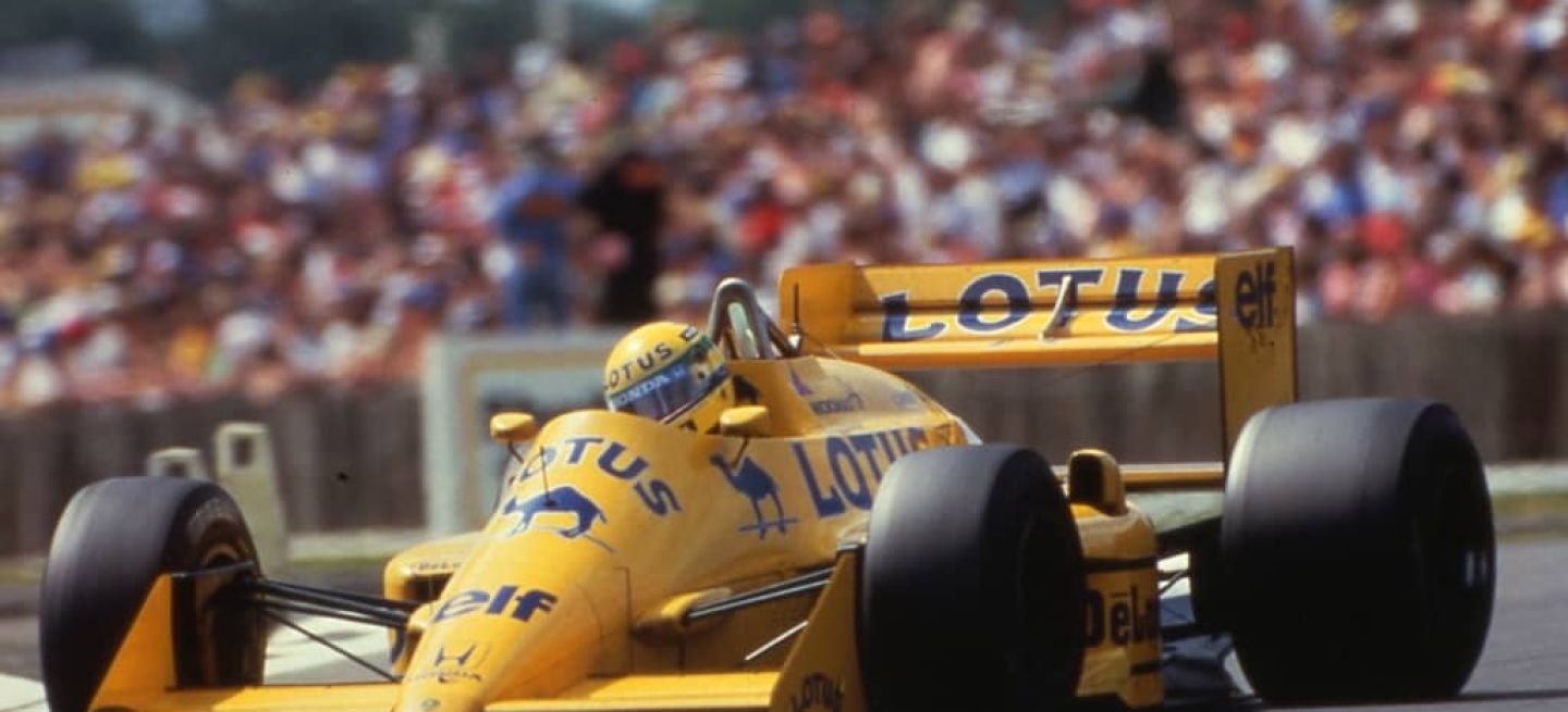 Lotus de F1 en acción, colores icónicos del casco de Ayrton Senna visibles