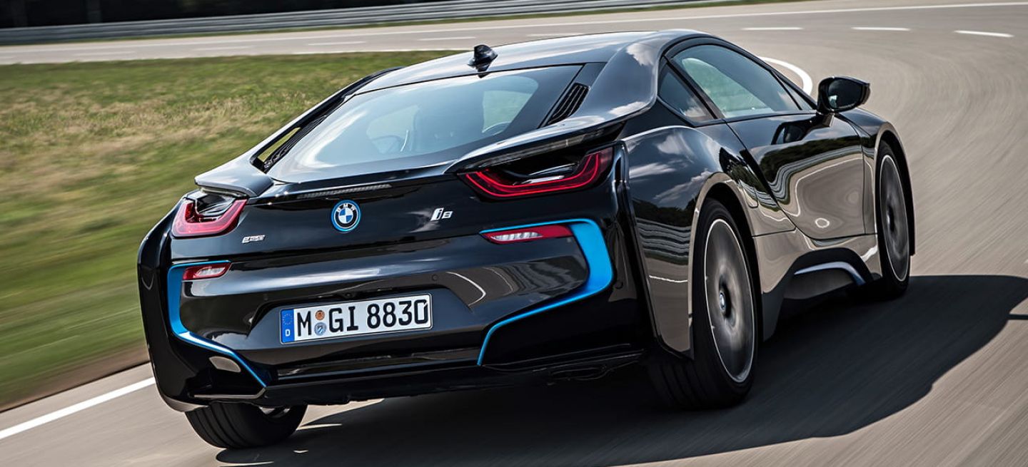 Vista trasera y lateral del BMW i8 en movimiento, realzando su diseño aerodinámico.