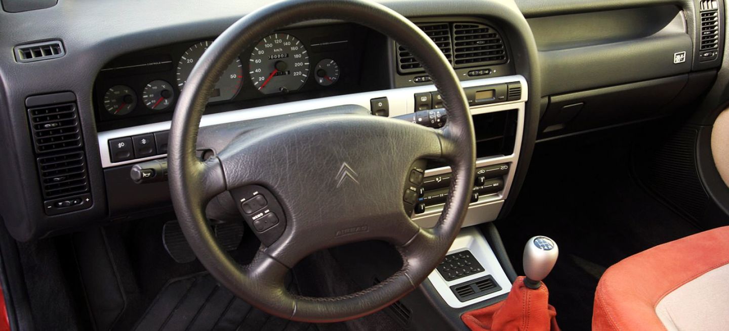 Vista de la cabina del Citroën Xantia, con enfoque en volante y asientos.