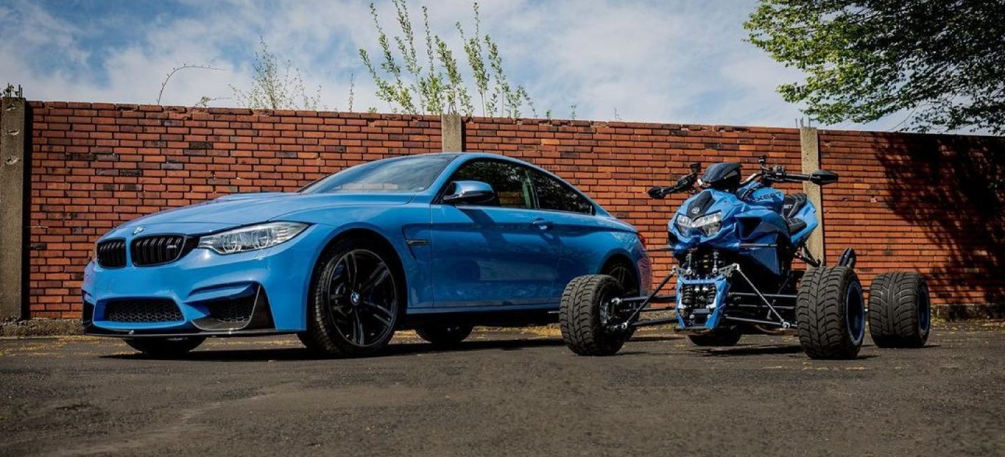 Exhibición de un BMW azul y un quad a juego en una pose desafiante