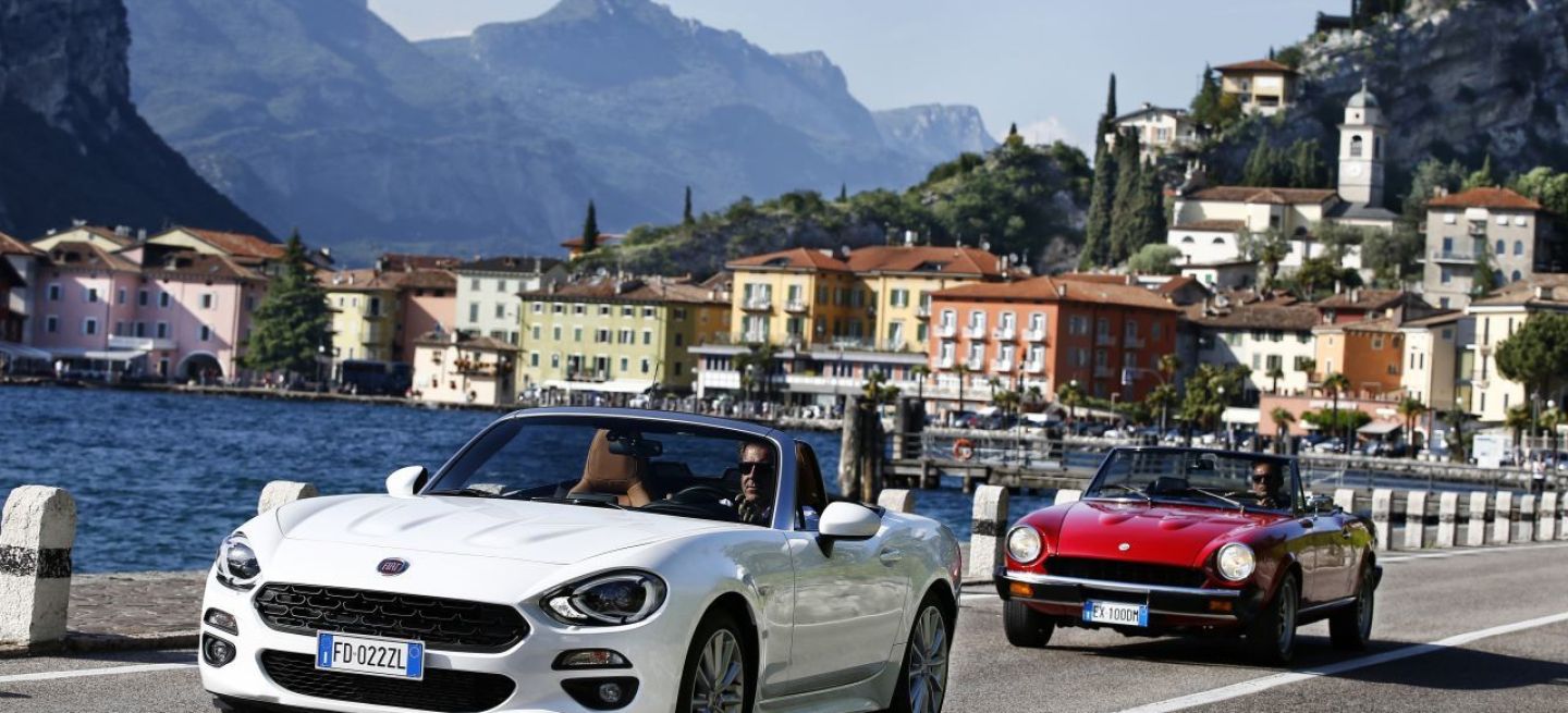 Fiat 124 Spider en movimiento, vista delantera y lateral.