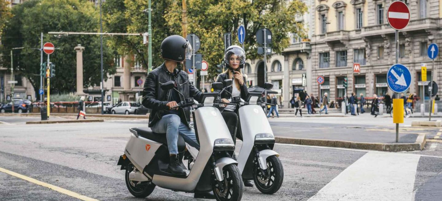 Dos scooters eléctricos Yadea circulando en entorno urbano.